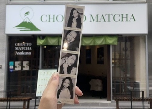 お店の前で、4カットのプリントを手に持っている写真。